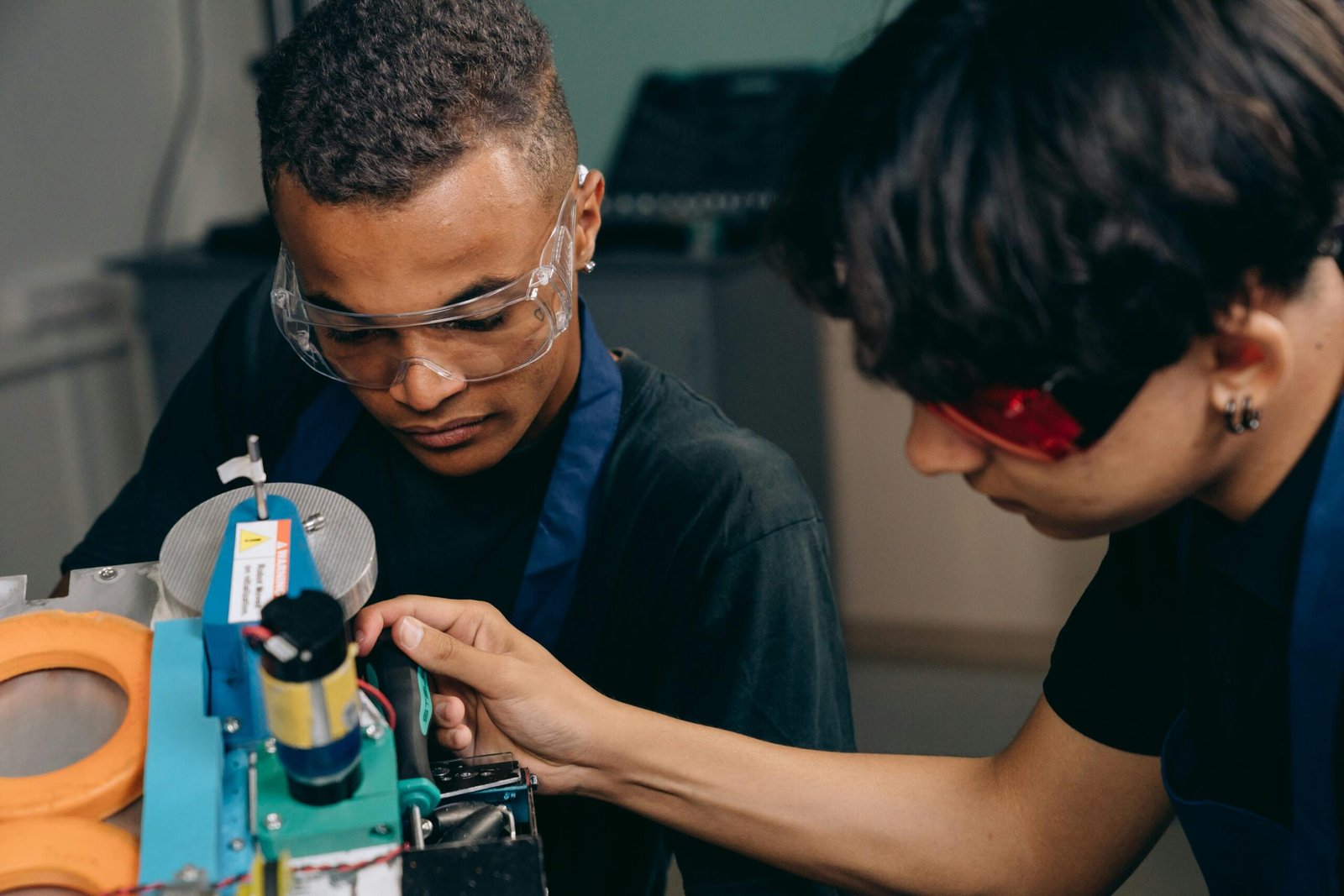 Two engineers collaborate on machinery operation in an industrial setting.